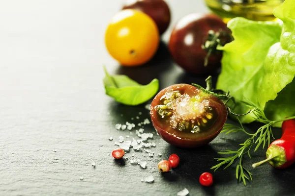 Tomates de uva frescos com folhas de salada e sal — Fotografia de Stock