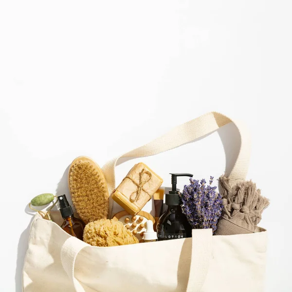 Eco-friendly tas reusable dengan produk perawatan kulit alami pada latar belakang putih, berbaring datar — Stok Foto