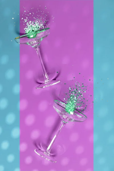 Deux verres à champagne avec éclaboussure de confettis sur fond créatif — Photo