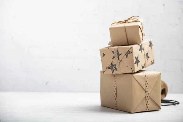 Stack of handcraft gift boxes on white brick background — Stock Photo, Image