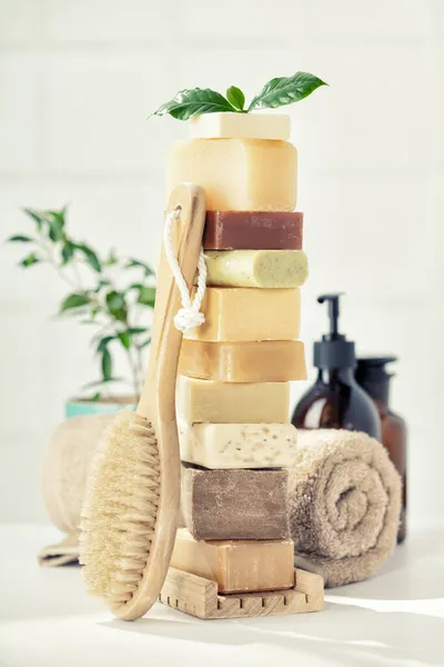 Стопка разнообразных натуральных мыльных батончиков на белой столешнице в ванной — стоковое фото