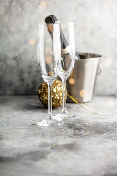 Botella de champán en cubo con hielo, vasos y decoraciones navideñas —  Fotos de Stock