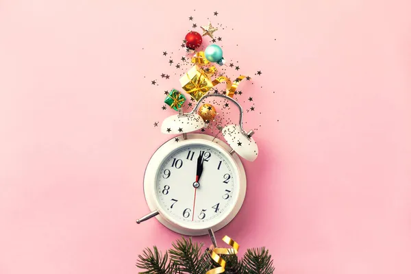 Composición de Navidad o Año Nuevo sobre fondo rosa con despertador retro y decoraciones navideñas — Foto de Stock