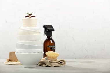 Sıfır atık ev temizlik konsepti, bulaşık fırçası, bulaşık fırçası, organik sabun barı, mutfak havlusu, ev bitkisi ve ekolojik kasa hepsi yeniden kullanılmış cam kavanozda temizleniyor, mesaj için boş alan.