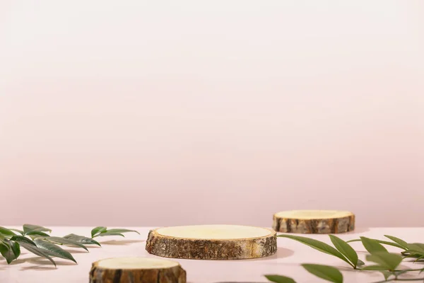 Podios de rodajas de madera sobre fondo rosa para maqueta de productos cosméticos —  Fotos de Stock