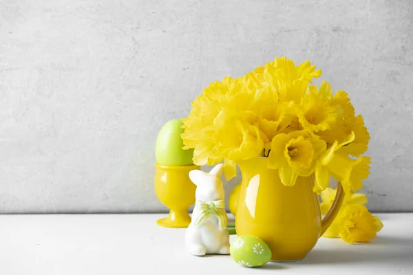 テーブルの上に黄色のジャグでイースターの卵、ウサギと黄色の水仙の花束、家の装飾、インテリア, — ストック写真