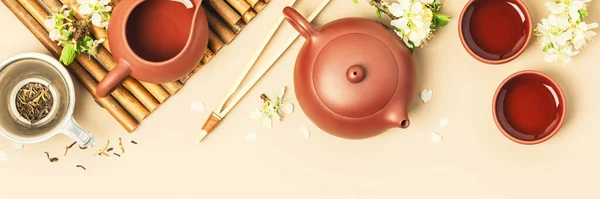 Thé asiatique sur panneau d'ardoise de pierre, théière en céramique, tasses, thé séché et branches de printemps — Photo