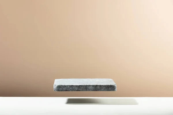 Flying Stone pódio para embalagem e apresentação cosmética. Modelo bege monocromático para mockup — Fotografia de Stock
