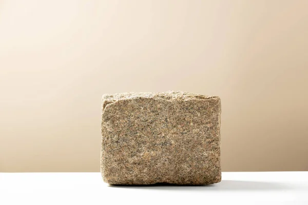 Каменный подиум для демонстрации упаковки и продукта на естественном бежевом фоне, копировальное пространство — стоковое фото