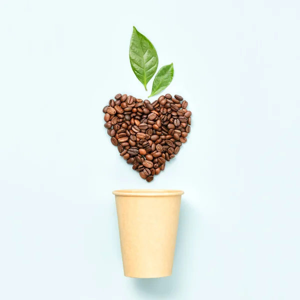 Bílý šálek kávy a kávová zrna ve tvaru srdce na bílém pozadí — Stock fotografie