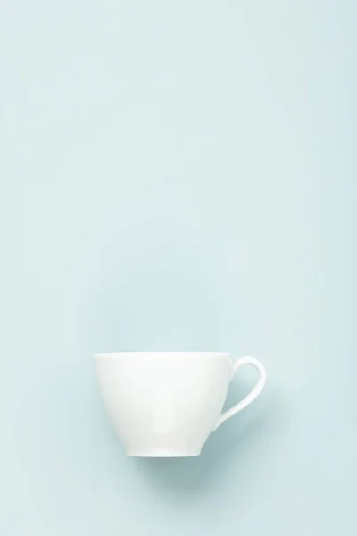 Blanco en blanco taza sobre fondo azul, plano laico, maqueta, espacio de copia — Foto de Stock