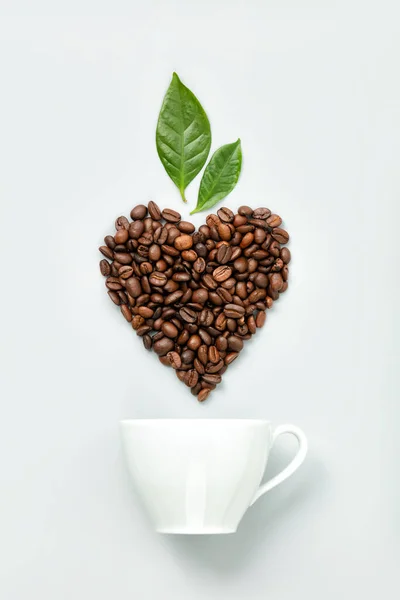 Caffè bianco e chicchi di caffè a forma di cuore su sfondo bianco, posa piatta — Foto Stock