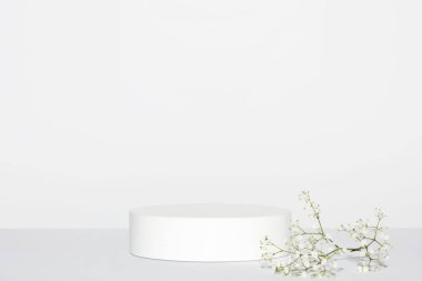 Gri arka planda beyaz çigila çiçekleri olan soyut beyaz podyum. Ürün sunumu için stand-up yapın. Üç boyutlu çizim. Minimum konsept. Reklam şablonu