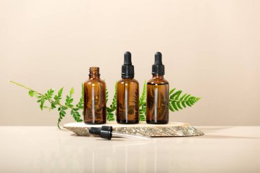 Kehribar cam şeffaf şişeler ahşap kürsüde. Doğal organik kozmetik ambalajlama, çevre dostu kozmetik ön görüş. Marka modellemesi için boş etiket