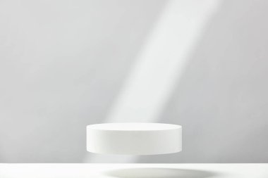 Abstract empty white podium with geometric shadows on blue background. Mock up stand for product presentation. 3D Render. Minimal concept. Advertising template