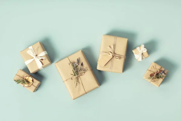 Christmas wrapping idea. Eco-Friendly, Sustainable, zero waste, natural color Christmas gift boxes on blue background