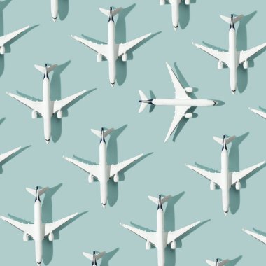 Pastel mavi arka planda beyaz yolcu uçağıyla yapılmış yaratıcı bir kompozisyon. Yaz seyahati ya da tatil düzeni. Düz konum, kare bileşim