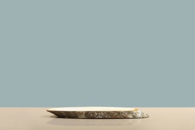 Round wooden saw cut cylinder shape on blue and beige background abstract background. Minimal box and geometric podium. Scene with geometrical forms. Empty showcase for eco cosmetic product