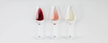 Banner. Flat-lay of red, rose and white wine in glasses on white background. Wine bar, winery, wine degustation concept. Minimalistic trendy photography