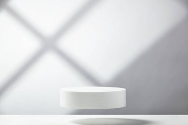 Mavi arka planda geometrik gölgeler olan soyut boş beyaz podyum. Ürün sunumu için stand-up yapın. Üç boyutlu çizim. Minimum konsept. Reklam şablonu