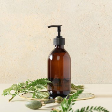 Kehribar cam şişeyi bej arka planda pompala. Sabun sıvısı, şampuan ya da duş jeli ambalaj tasarımı. Güzellik blogu, kuaför tedavisi konsepti, minimalizm marka paketleme maketi