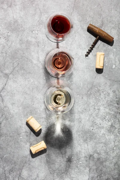 Wine composition with beautiful sunlight and shadows on grey background. Top view, flat lay. Wine bar, winery, wine degustation concept. Minimalistic trendy photography