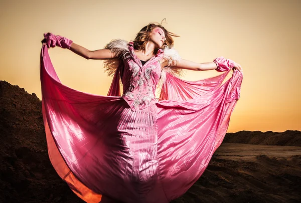 Attraktive romantische Frau auf schönem rosa Kleid posiert im Freien. — Stockfoto