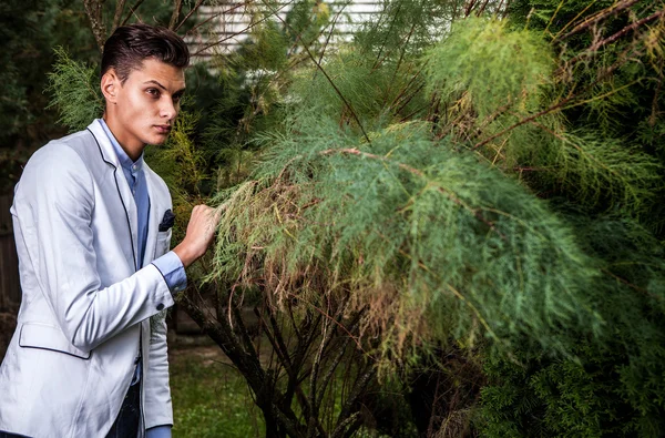 Retrato de jovem belo homem elegante contra o jardim de outono . — Fotografia de Stock