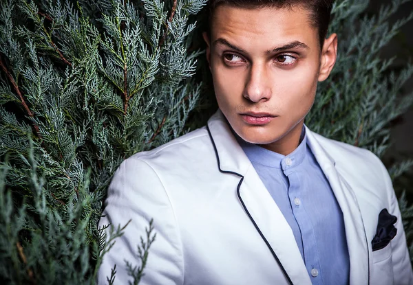 Portrait of young beautiful fashionable man against autumn garden. — Stock Photo, Image