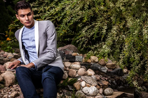 Portrait de jeune bel homme à la mode contre jardin d'automne . — Photo