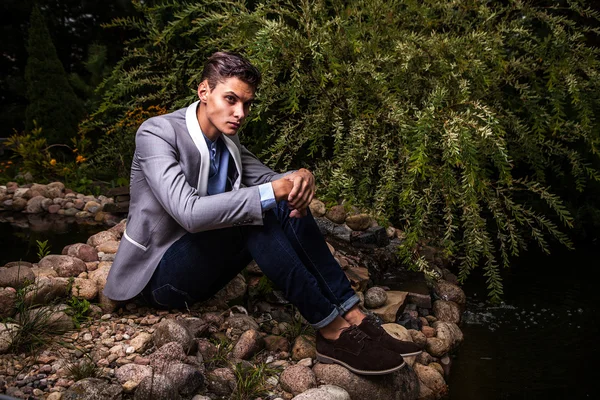 Retrato de joven hermoso hombre de moda contra el jardín de otoño . — Foto de Stock