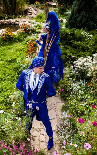Пара в дорогом темно-синем костюме иллюзионистской позы в парке цветов сказки . — стоковое фото
