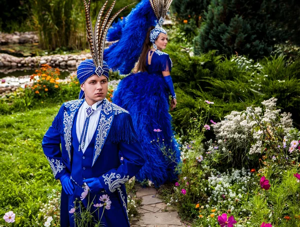 Para w drogie ciemny niebieski strój złudzenie stanowią bajki kwiaty Park. — Zdjęcie stockowe