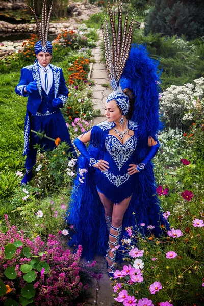 Pareja en traje azul oscuro caro de pose ilusionista en parque de flores de cuento de hadas . —  Fotos de Stock