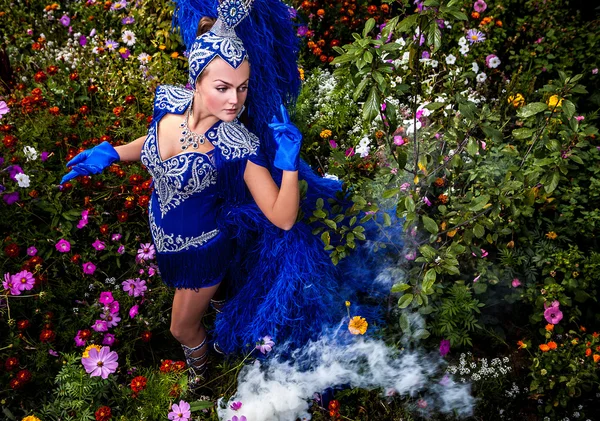 Žena v drahých exotických Karneval kostým pozice v lučních květů. — Stock fotografie