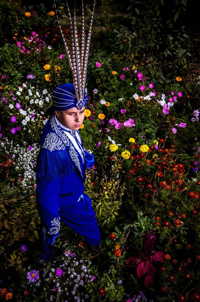 Homem em terno azul escuro caro de pose ilusionista no prado da flor . — Fotografia de Stock