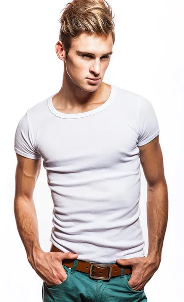 Aantrekkelijke man die t-shirt dicht omhoog portret op witte achtergrond. — Stockfoto