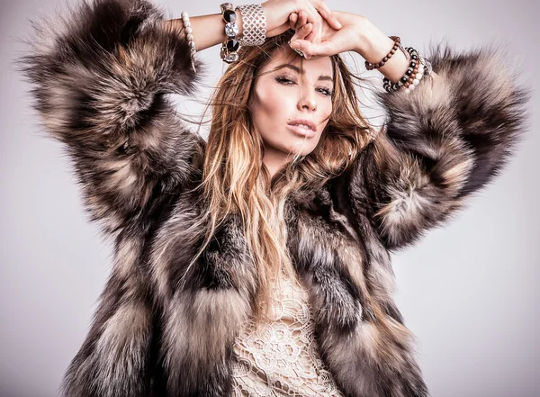 Portrait of attractive stylish woman in fur against grey background. — Stock Photo, Image