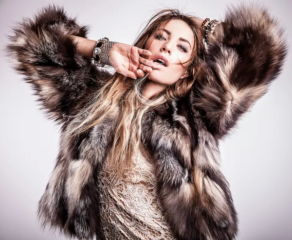 Portrait of attractive stylish woman in fur against grey background. — Stock Photo, Image