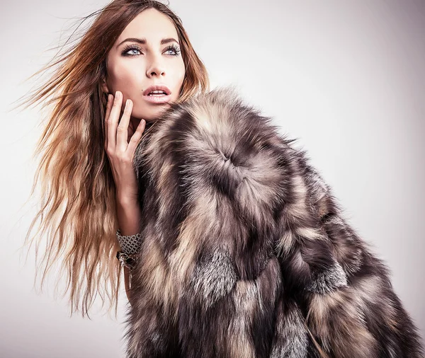 Portrait of attractive stylish woman in fur against grey background. — Stock Photo, Image