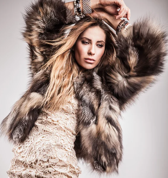 Portrait of attractive stylish woman in fur against grey background. — Stock Photo, Image