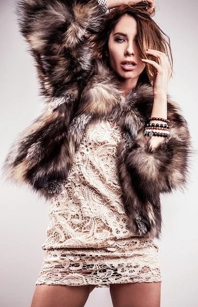 Портрет привлекательной стильной женщины в мехе на сером фоне . — стоковое фото