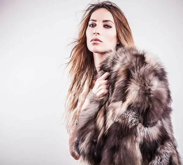 Portrait of attractive stylish woman in fur against grey background. — Stock Photo, Image