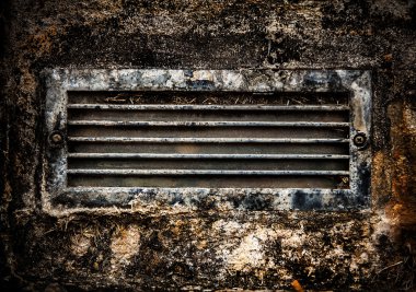 taş duvara gömülü eski paslı kirli havalandırma ızgara.
