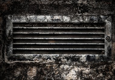 taş duvara gömülü eski paslı kirli havalandırma ızgara.