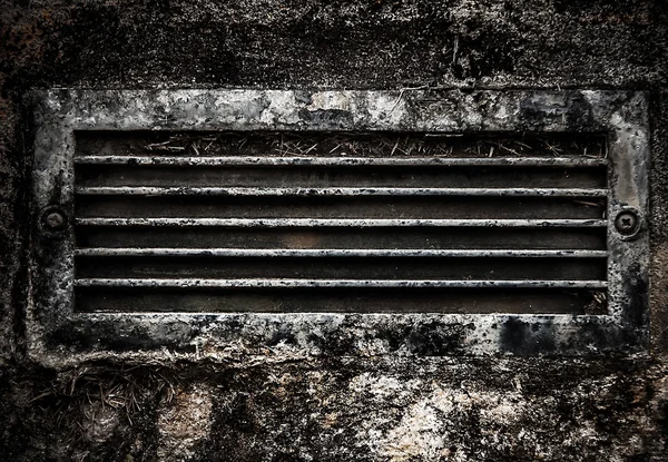 Old rusty dirty ventilation grid embedded in stone wall. — Stock Photo, Image