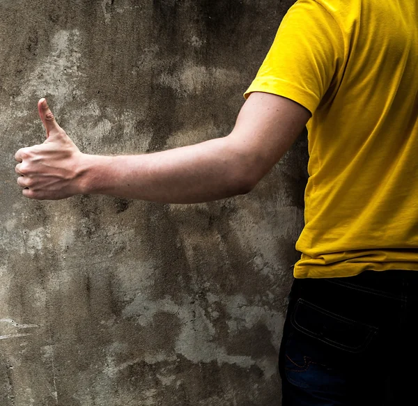 Homme signe à la main sur vieux fond de mur de pierre . — Photo