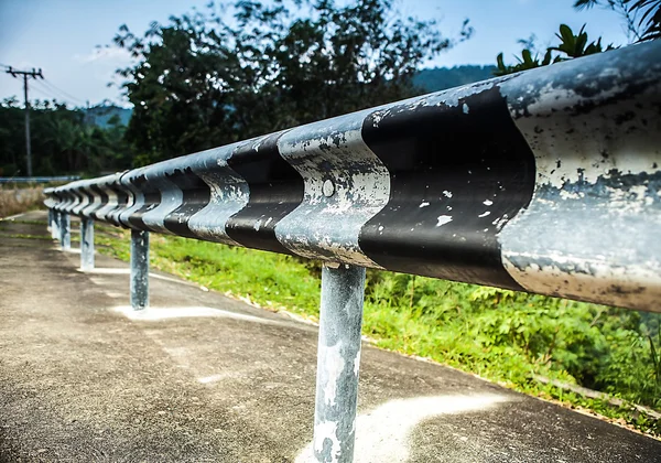 Cerca velha listrada ao lado da estrada — Fotografia de Stock