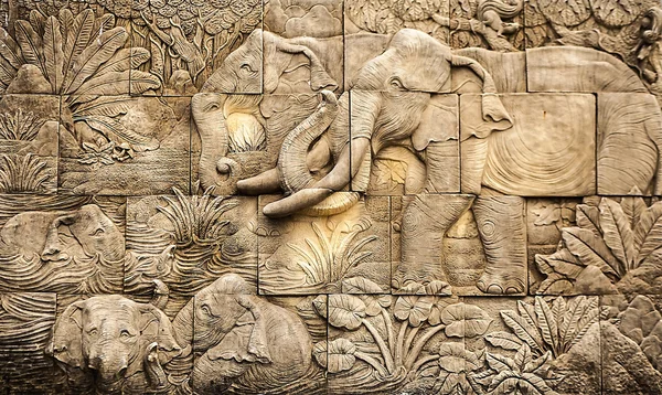 Traditional asian image cut from stone on a wall. — Stock Photo, Image