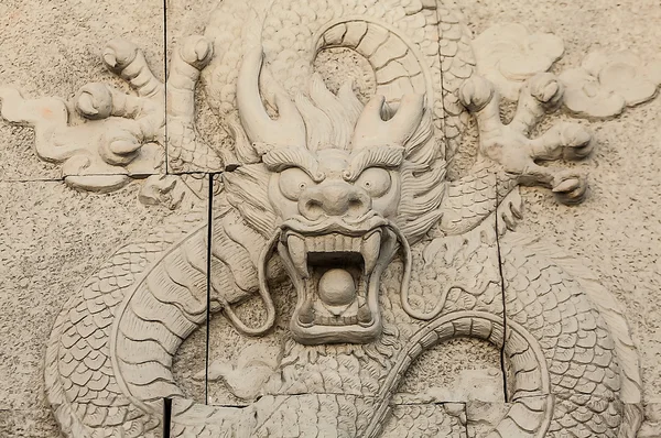 Traditional asian image cut from stone on a wall. — Stock Photo, Image